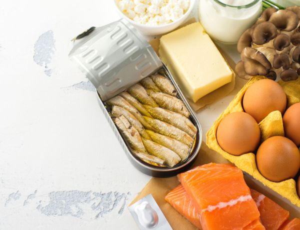Auswahl an Lebensmitteln wie Fisch, Käse, Eier und Obst als natürliche Vitamin-D-Quelle.