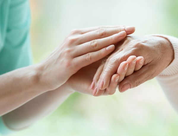 Hände eines älteren Paares, die sich berühren, als Zeichen für Demenz und Fürsorge.