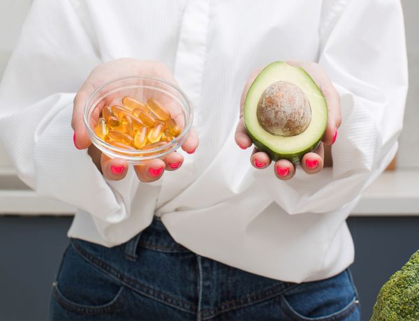 Kapsel und Avocado als Symbol für Vitamin-D-reiche Ernährung.