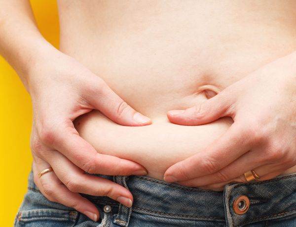 Person legt beide Hände auf den Bauch
