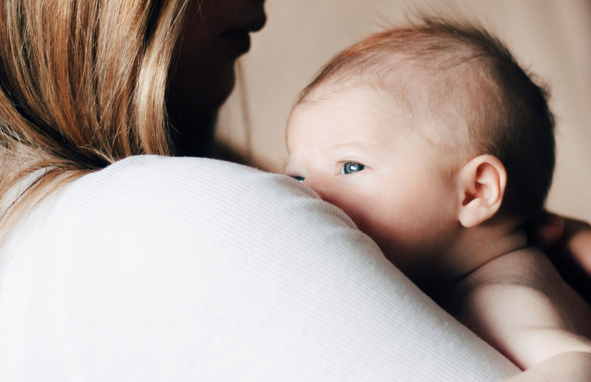 Baby schaut über Mutters Schluter