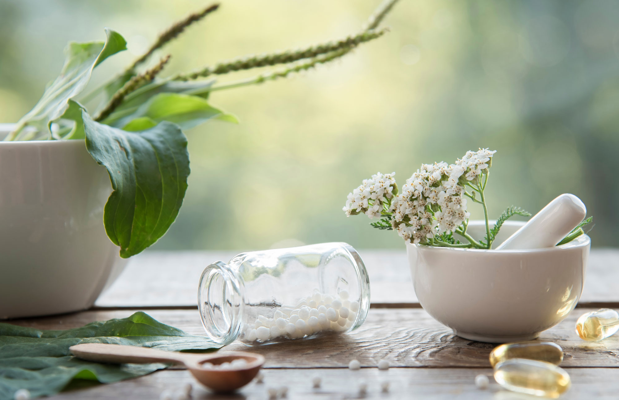 Globuli-Fläschchen und Blüten als Symbol für Homöopathie.