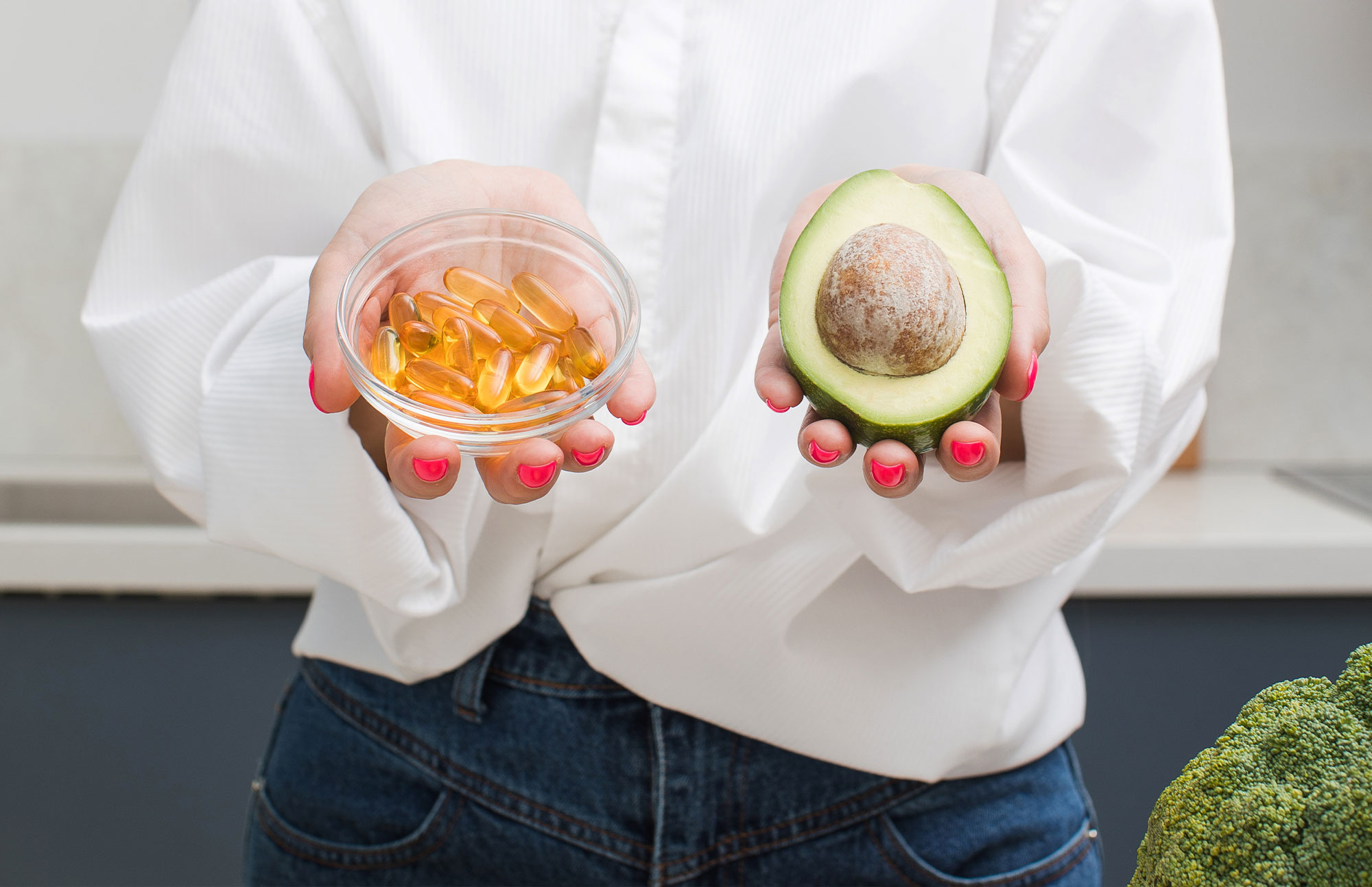 Kapsel und Avocado als Symbol für Vitamin-D-reiche Ernährung.